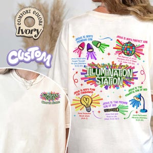 May include: Ivory-colored Comfort Colors t-shirt with a custom design. The design features the words "ILLUMINATION STATION" with religious graphics and text, including "Jesus is God's Promised Son" and "Jesus is God's Perfect Son."