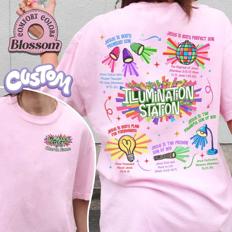 May include: A light pink t-shirt with a graphic design featuring the text "ILLUMINATION STATION" and various religious illustrations. The shirt also includes the text "Church Name" and other religious phrases.