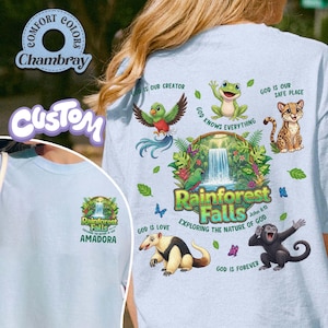 May include: Pale blue t-shirt with a rainforest-themed graphic, including a waterfall, various animals, and the words "Rainforest Falls." The shirt also features the text "Exploring the Nature of God" and "Amadora."