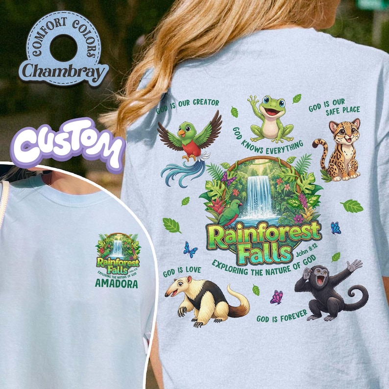May include: Pale blue t-shirt with a rainforest-themed graphic, including a waterfall, various animals, and the words "Rainforest Falls." The shirt also features the text "Exploring the Nature of God" and "Amadora."