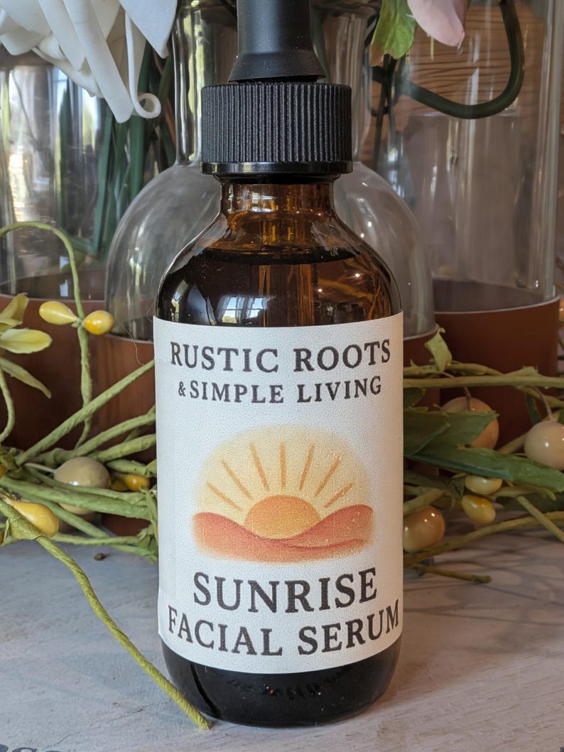 Puede incluir: Una botella de vidrio marr&oacute;n con un tap&oacute;n cuentagotas negro. La etiqueta dice "RUSTIC ROOTS & SIMPLE LIVING" y "SUNRISE FACIAL SERUM" con un gr&aacute;fico de amanecer. La botella contiene un l&iacute;quido oscuro.