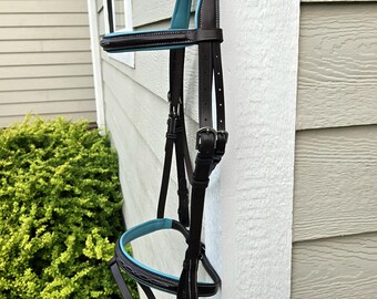 Briglia inglese con cuciture decorative e imbottitura in pelle turchese, misura per cavallo adulto, con redini in gomma abbinate.