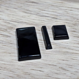 May include: Three black rectangular pieces of polished onyx, two are longer and one is shorter.