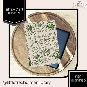 May include: An e-reader insert with a green and white pattern featuring a drink, hearts, and the words "boy mom" and "teacher." The insert is on a wooden tray with a black e-reader. Text on the insert includes "FREE" and "psychological thriller."