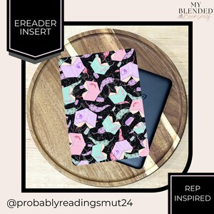 May include: An eReader insert with a black background and a pattern of open books in pastel colors. The insert is on a wooden tray with a black eReader. Text on the insert reads "EREADER INSERT". The text "REP INSPIRED" is also visible.