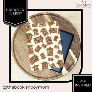 May include: An eReader insert with a repeating pattern of illustrated bookshelves on a cream background. The insert is placed on a wooden tray with a black eReader partially visible. Text on the insert reads "TBD" and "REP INSPIRED".
