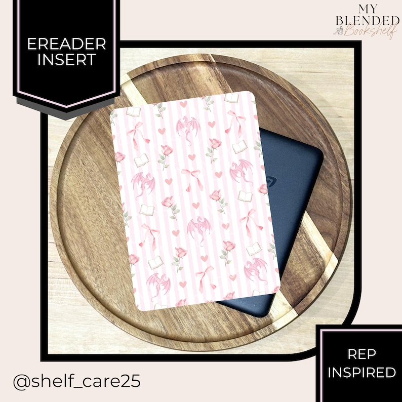 May include: An eReader insert with a pink and white striped pattern featuring pink dragons, hearts, and flowers. The insert is on a wooden tray with a black eReader. Text on the insert reads "EREADER INSERT". The text "REP INSPIRED" is also visible.