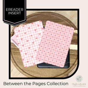 May include: Two pink eReader inserts with heart patterns, one in a gingham design and the other with a repeating heart pattern. The inserts are on a wooden surface. The text "Ereader Insert" is in a black box. The text "Between the Pages Collection" is at the bottom.
