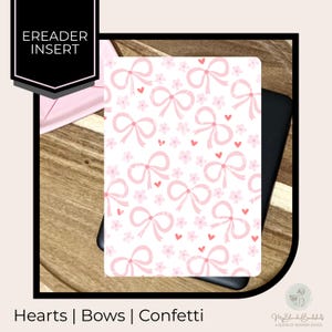 May include: A white e-reader insert with a pattern of pink bows, hearts, and flowers. The text "Hearts | Bows | Confetti" is at the bottom. The insert is on a wooden surface.