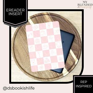 May include: An eReader insert with a pink and white checkered pattern featuring various icons, placed on a wooden tray with a black eReader. The insert is labeled "EREADER INSERT" and the design is "REP INSPIRED". The Instagram handle @dsbookishlife is also visible.