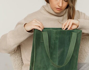Pode incluir: Uma bolsa tote de couro verde com formato estruturado e duas alças superiores. A bolsa é feita de couro texturizado e tem um brilho sutil.