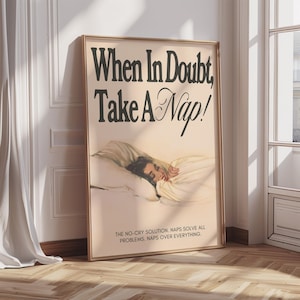 Può includere: Un poster incorniciato con la scritta "When In Doubt, Take A Nap!" in corsivo nero. L'immagine mostra una persona che dorme a letto. La parte inferiore del poster recita: "THE NO-CRY SOLUTION. NAPS SOLVE ALL PROBLEMS. NAPS OVER EVERYTHING."