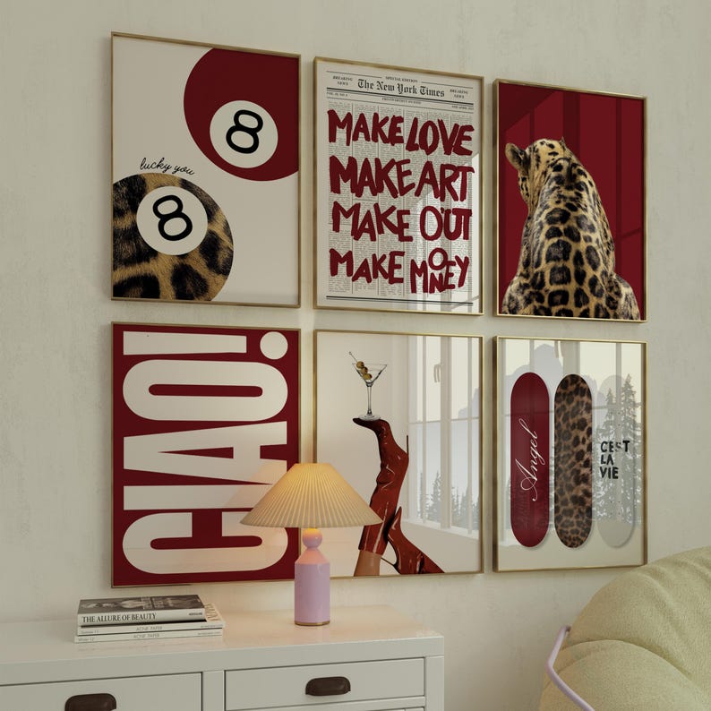May include: A collection of framed art prints with gold frames. The prints feature various designs, including an 8-ball with leopard print, text from The New York Times, a leopard, the word "CIAO!", a martini, and skateboards with text and leopard print.