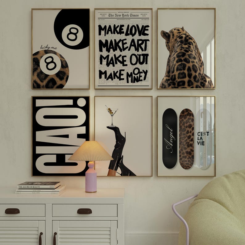 May include: A collection of framed art prints with gold frames. The prints feature a black and white 8-ball, text that reads "Make Love, Make Art, Make Out, Make Money", a leopard, the word "CIAO!", a martini glass, and skateboards.