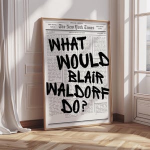 Pode incluir: Impressão emoldurada com um design de jornal, incluindo o título "The New York Times". A impressão apresenta o texto "WHAT WOULD BLAIR WALDORF DO?" em negrito e preto. A moldura é dourada.