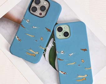 May include: Two blue phone cases with a repeating pattern of cartoon dachshunds swimming in water. The cases have a matte finish and are designed for different phone models. The dachshunds are in various colors, including brown, white, and tan.