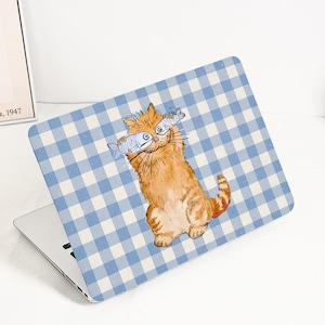 May include: Laptop skin featuring a cartoon orange tabby cat holding two fish, set against a blue and white checkered background. The laptop is open, displaying the skin design. The overall theme is playful and whimsical.