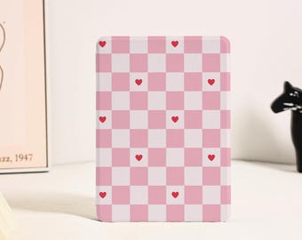 May include: A rectangular e-reader or tablet case featuring a repeating checkered pattern in alternating light pink and white squares. Small, solid red hearts are centered within select squares across the grid, creating a consistent graphic design.