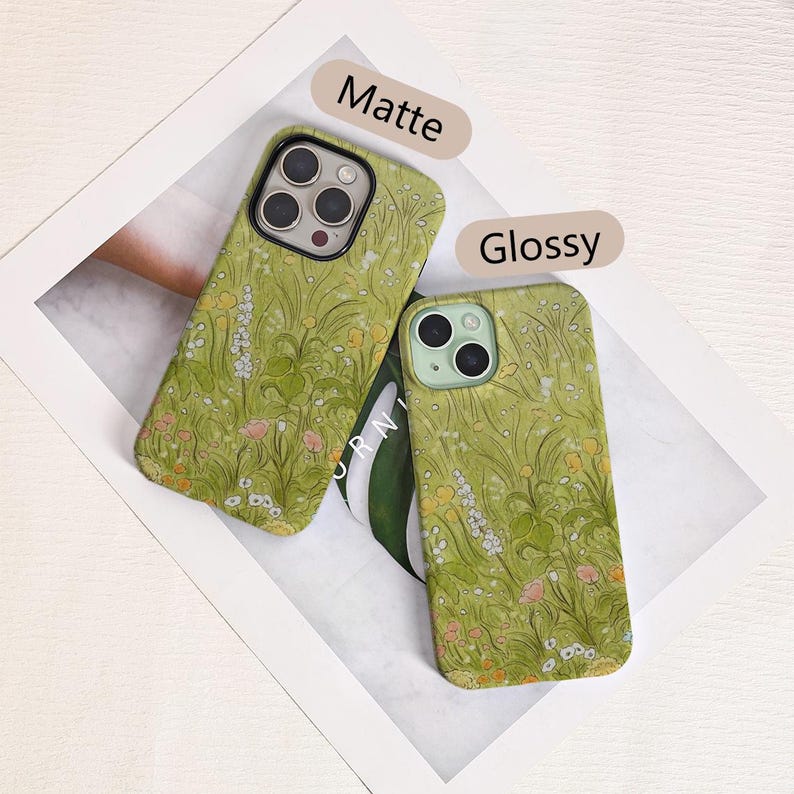 May include: Two phone cases with a floral design in shades of green, yellow, and pink. One case has a matte finish, and the other has a glossy finish. The word "Matte" is above one case, and "Glossy" is above the other.