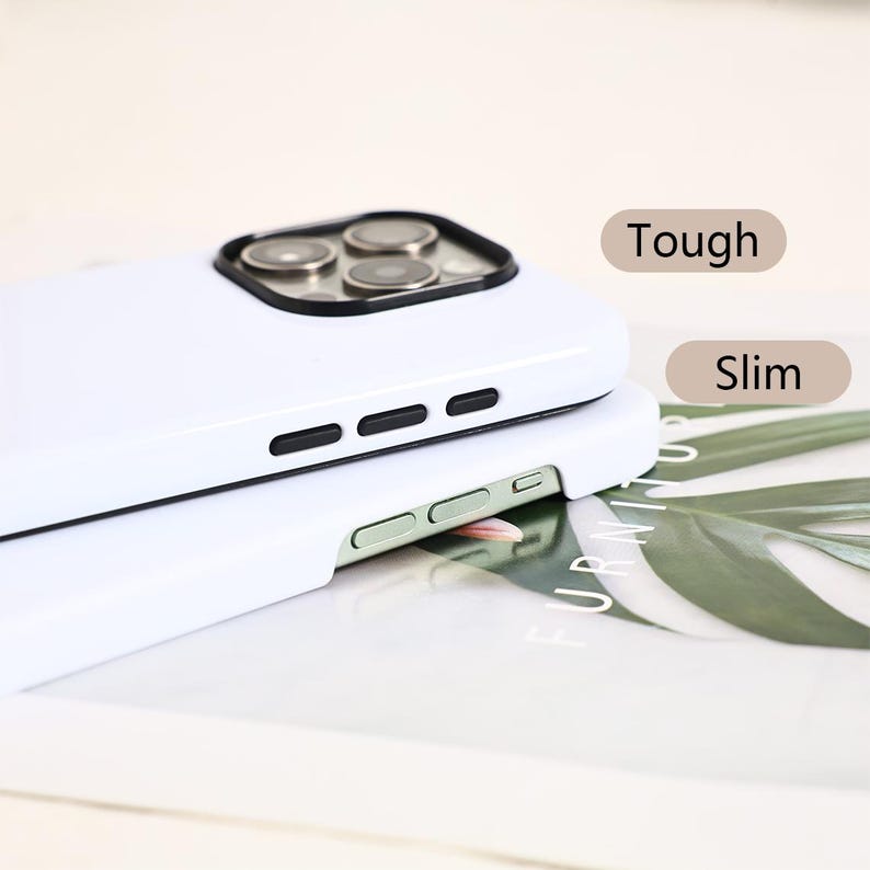 May include: Two white phone cases stacked on top of each other. The top case has a camera cutout with black trim and three black buttons. The bottom case has two green buttons. The words "Tough" and "Slim" are visible.