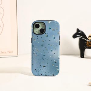 May include: A light blue phone case with a star pattern. The case has a glossy finish and a black border. The camera lens is visible at the top. The case is designed to fit a smartphone.