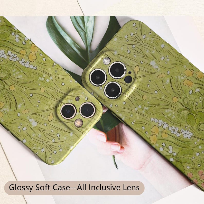May include: Two glossy green phone cases with a floral pattern. The cases have a soft texture and feature a design of white and yellow flowers and green leaves. The text "Glossy Soft Case--All Inclusive Lens" is at the bottom.