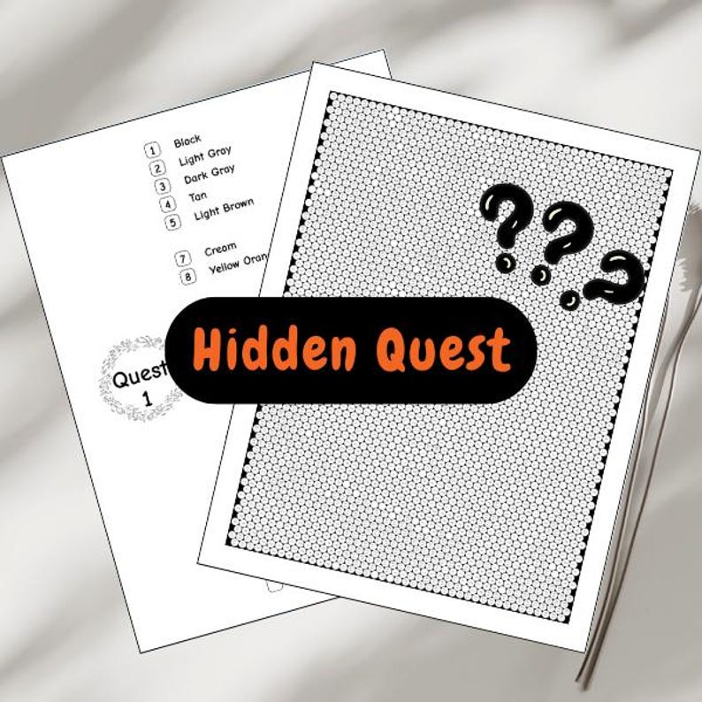 May include: Two white sheets of paper with a black dotted border. One sheet has a list of color names, and the other has question marks and the text "Hidden Quest" in orange. A metal utensil is visible.
