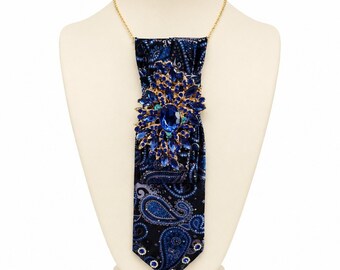 Collana con cravatta a fantasia paisley blu e spilla removibile, gioiello unico e di grande impatto.