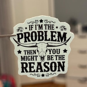 May include: A white sticker with a black skull and crossbones design. The sticker says "If I'm the problem, then you might be the reason".