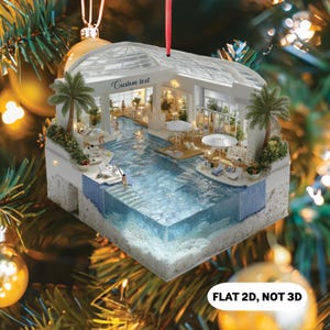 May include: A decorative Christmas ornament featuring a swimming pool scene with palm trees, sun loungers, and a glass roof. The ornament has the text "Custom text" and "FLAT 2D, NOT 3D". It is suspended by a red ribbon.