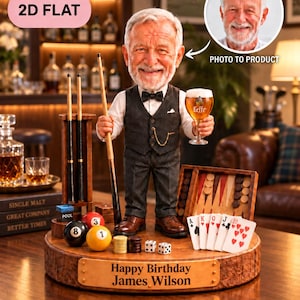 Puede incluir: Una figura cabezona personalizada de un hombre mayor con barba blanca, vistiendo un chaleco oscuro, camisa blanca y pajarita. La figura sostiene un taco de billar y una copa de cerveza Leffe. Se apoya sobre una base de madera con una placa que dice Happy Birthday James Wilson, rodeada de bolas de billar, dados, cartas y un tablero de backgammon.