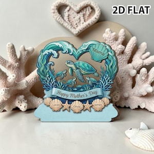 Pode incluir: Decoração de madeira para o Dia das Mães com um design em forma de coração com uma tartaruga marinha e seus filhotes. O design inclui o texto "Happy Mother's Day", nomes e detalhes de conchas. O fundo inclui corais e uma decoração em forma de coração.