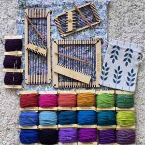 May include: A weaving kit featuring three wooden looms, wooden shuttles, and combs with etched designs. Includes eighteen spools of colorful yarn in shades of red, blue, green, and purple, plus two fabric drawstring bags with floral and leaf patterns.