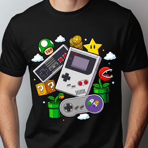 Może przedstawiać: Czarny t-shirt z kolorową grafiką klasycznych elementów gier wideo. Projekt zawiera zielonego grzyba, gwiazdę, monety, bloki ze znakiem zapytania, kontroler i Game Boy. Zabawny element odzieży w stylu retro.