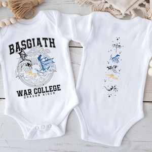 Pode incluir: Body de bebé branco com um design de dragão. A frente apresenta o texto "BASGIATH WAR COLLEGE DRAGON RIDER" com ilustrações de dragões. A parte de trás tem ilustrações de dragões em linha vertical. Um presente de bebé único.