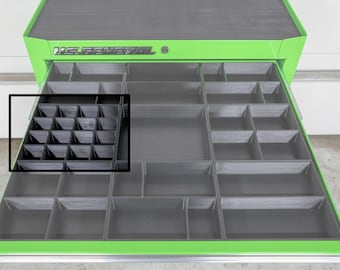 May include: A green and black US General tool chest with an open drawer revealing a black organizer insert. The drawer is divided into multiple compartments of varying sizes, designed for tool storage and organization. The tool chest is on a white surface.