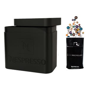 Puede incluir: Un contenedor de reciclaje Nespresso negro con tapa y el logotipo de Nespresso. El contenedor está al lado de una bolsa negra con las palabras "We Recycle" y el logotipo de Nespresso.