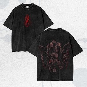 Puede incluir: Dos camisetas negras con acabado desgastado. Una camiseta presenta un diseño abstracto rojo en la parte delantera. La otra muestra un gráfico detallado en rojo y marrón de una criatura en la parte posterior. Ambas camisetas tienen mangas cortas y cuello redondo.