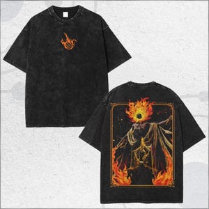 May include: Black acid wash t-shirt with a small orange flame design on the front and a larger illustration on the back. The back graphic features a figure with a flaming head and a gold frame.