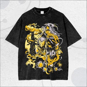 May include: Black t-shirt with a distressed wash featuring a yellow and white graphic design. The graphic depicts a warrior with a helmet, a skull, and other fantasy elements. The shirt has short sleeves and a crew neck.