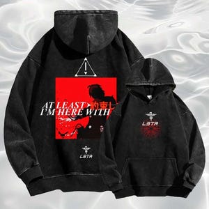 May include: Two black hoodies with distressed wash. One hoodie features a red square with white text and a silhouette. The other hoodie has a white logo and a red circular design. Both hoodies have a hood and a front pocket.
