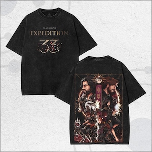 Puede incluir: Camiseta negra con el texto dorado "CLAIR OBSCUR EXPEDITION 33". La parte trasera de la camiseta presenta un gráfico detallado de personajes en un entorno de fantasía, con un marco dorado y una paleta de colores oscuros.
