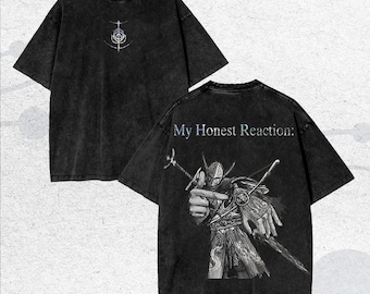 May include: Two-sided, dark gray t-shirts. The front features a white and light blue graphic. The back displays a detailed illustration of a warrior with the text "My Honest Reaction:" in light blue.