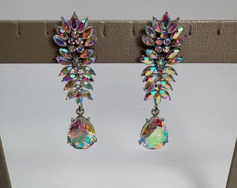 May include: A pair of dangling earrings featuring a silver-toned metal setting adorned with iridescent, multi-colored marquise-cut crystals arranged in a leaf-like pattern, finished with a single large, pear-shaped iridescent crystal drop at the base.