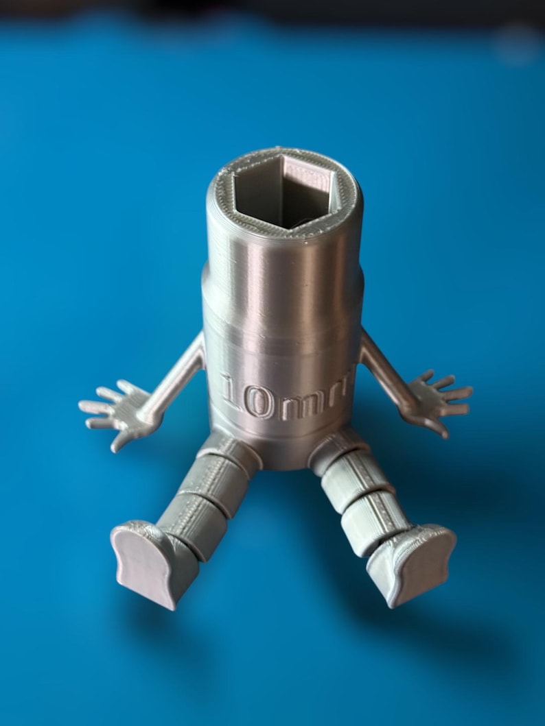 May include: A silver 3D printed wrench with arms and legs. The wrench is 10mm and has a hexagonal opening.