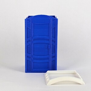 May include: A blue plastic portable toilet model with a white plastic lid. The toilet has a door and a handle.