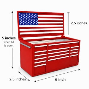 May include: A red tool chest with a hinged lid featuring an American flag design. The chest measures 6 inches wide, 2.5 inches deep, and 5 inches high when the lid is open, with the lid itself measuring 2.5 inches in height.