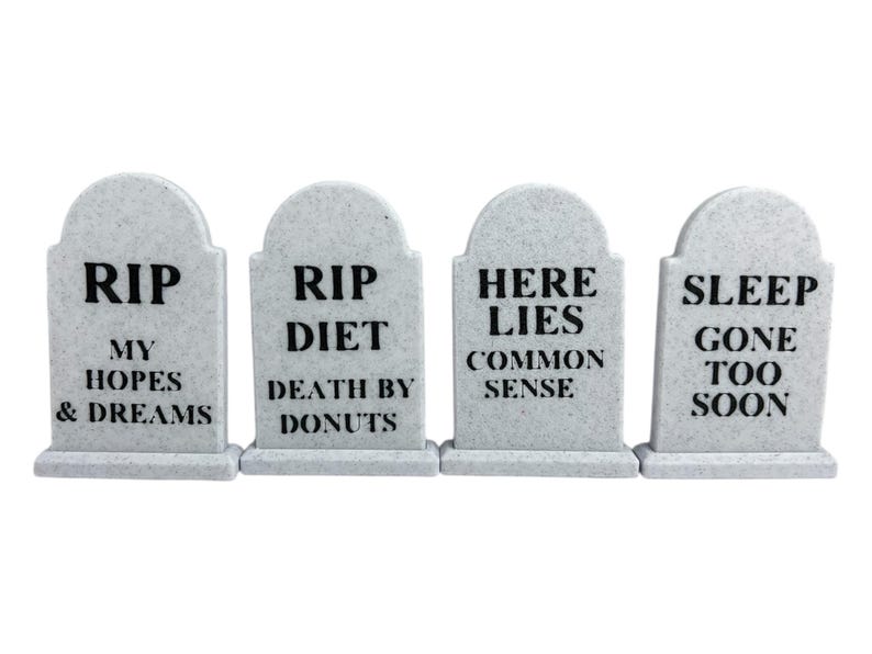 May include: Four gray tombstones with black text. The tombstones read: "RIP MY HOPES & DREAMS", "RIP DIET DEATH BY DONUTS", "HERE LIES COMMON SENSE", and "SLEEP GONE TOO SOON".