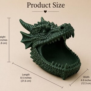 May include: A dark green dragon head-shaped container. The container is 5.4 inches (13.8 cm) high, 8.5 inches (21.6 cm) long, and 4.8 inches (12.3 cm) wide. The dragon has detailed scales, horns, and sharp teeth. The product size is displayed above the container.