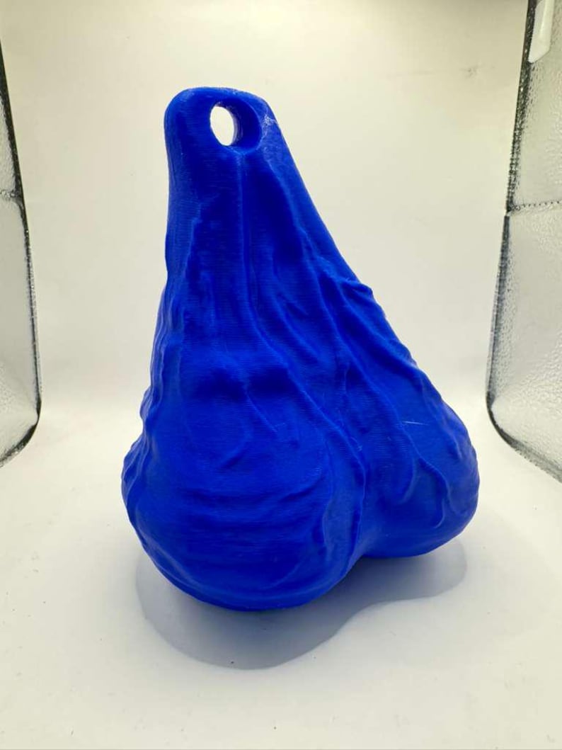 May include: A bright blue, three-dimensional object with a textured, organic surface and a rounded, bulbous shape. The top section features a single, circular hole, while the lower portion consists of two distinct, rounded lobes.